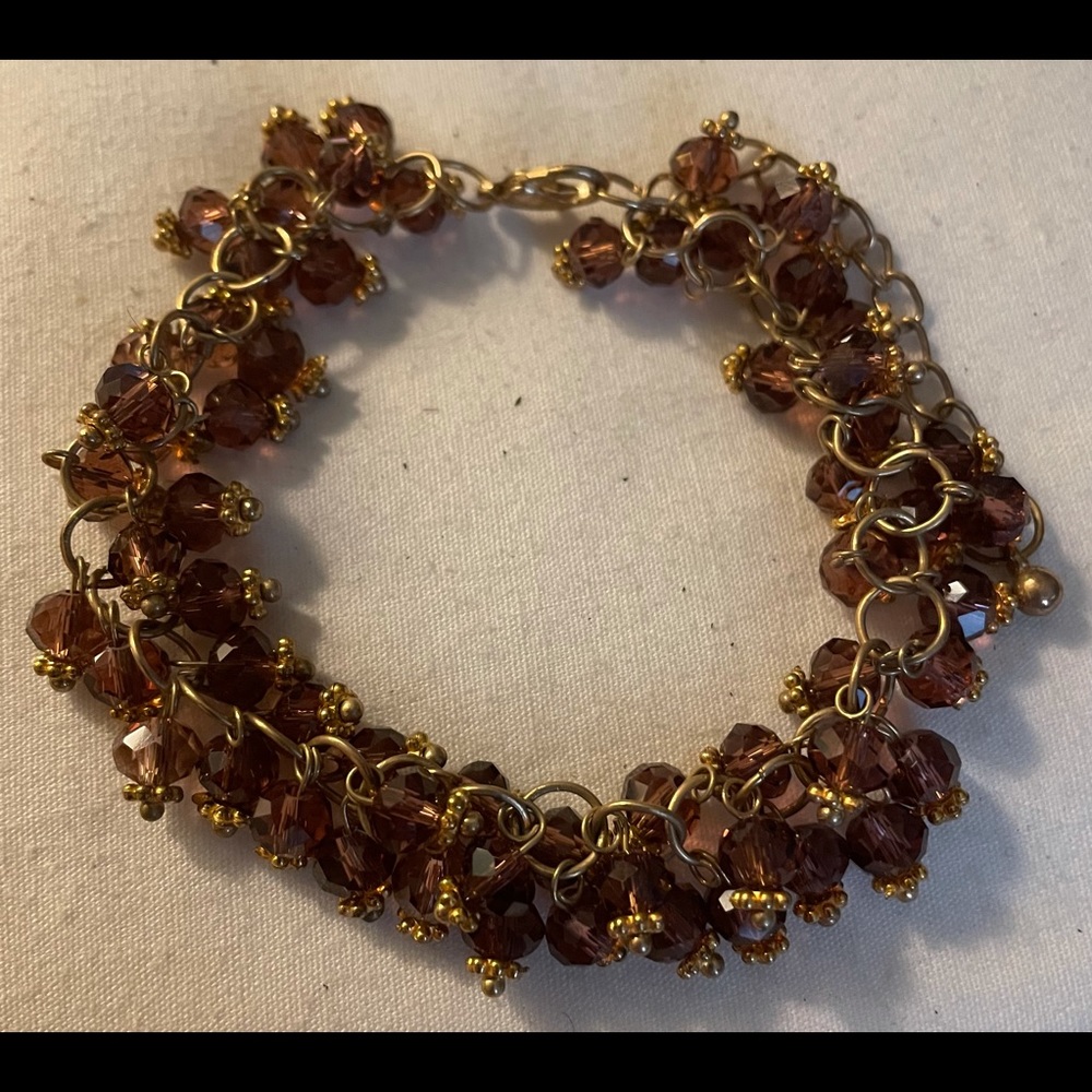 8 inch adjustable beaded bracelet with red stones on a gold tone chain
